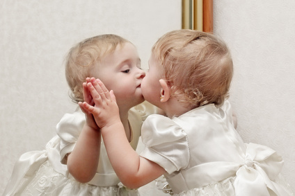 Bébé qui embrasse sa réflexion dans un miroir
